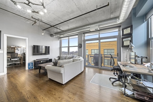 living room featuring a towering ceiling and dark hardwood / wood-style floors