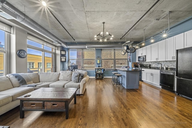 living room featuring dark hardwood / wood-style floors, sink, and an inviting chandelier