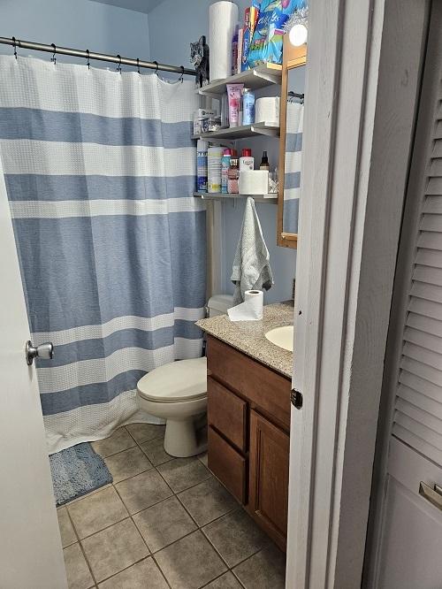 bathroom with tile patterned flooring, vanity, and toilet