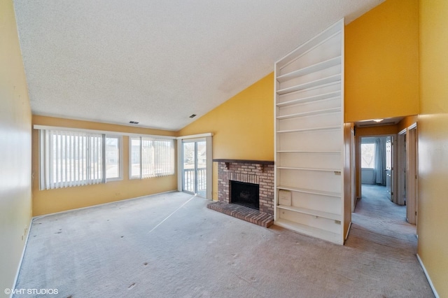 unfurnished living room with a brick fireplace, light colored carpet, built in features, and a textured ceiling