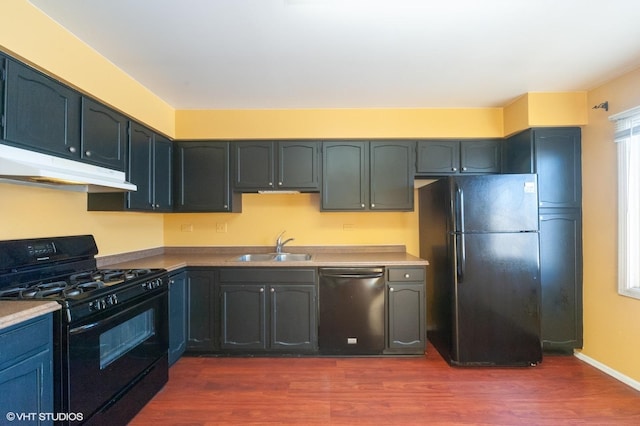 kitchen featuring sink, dark wood-type flooring, and black appliances