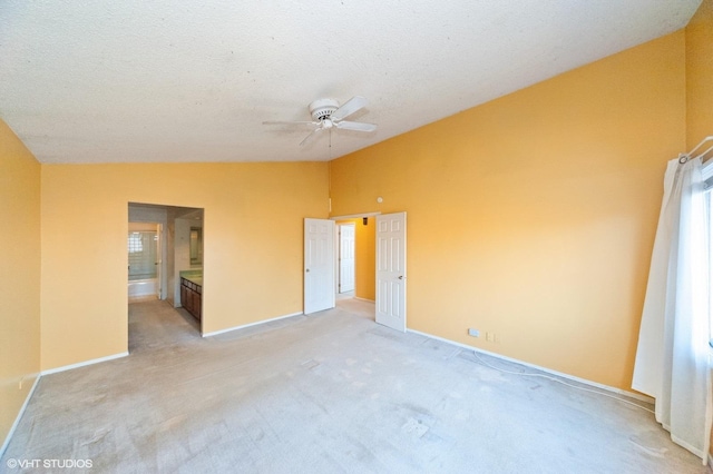 carpeted spare room featuring lofted ceiling, ceiling fan, and a textured ceiling