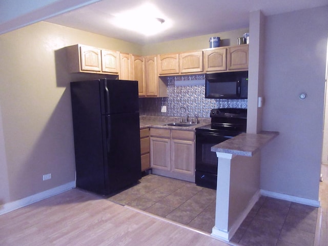 kitchen featuring light brown cabinetry, sink, decorative backsplash, and black appliances