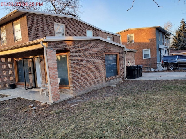 rear view of property featuring a lawn and a patio area