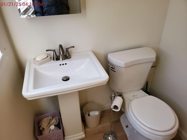 bathroom with wood-type flooring, sink, and toilet