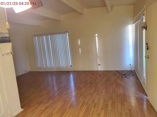 unfurnished living room with beamed ceiling and light hardwood / wood-style floors