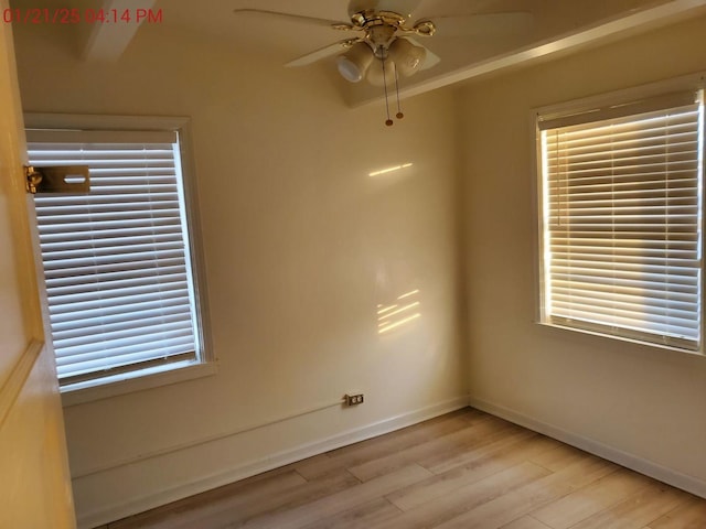 empty room featuring plenty of natural light, ceiling fan, and light hardwood / wood-style flooring