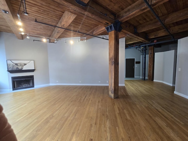 basement with wood-type flooring, wooden ceiling, and track lighting