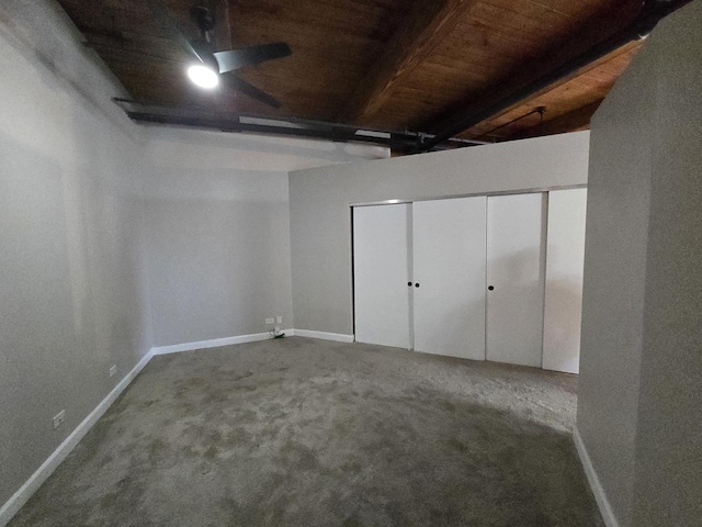 unfurnished bedroom featuring beamed ceiling, ceiling fan, carpet floors, and wooden ceiling