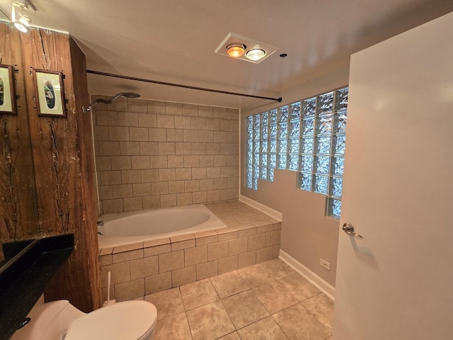 bathroom with toilet, tiled shower / bath combo, and tile patterned flooring