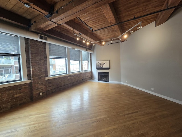 unfurnished living room with brick wall, wood-type flooring, and wooden ceiling