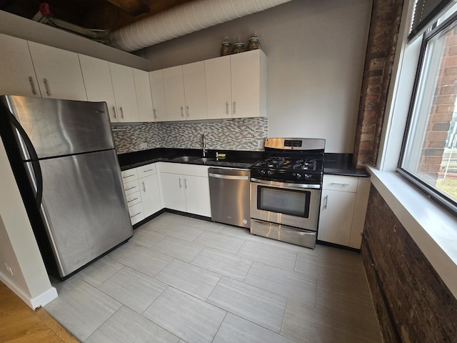 kitchen with tasteful backsplash, stainless steel appliances, sink, and white cabinets