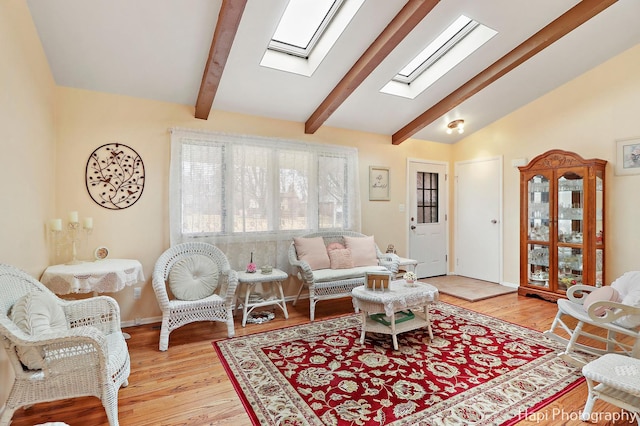 living room with light hardwood / wood-style flooring and lofted ceiling with skylight