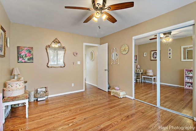 sitting room with ceiling fan and light wood-type flooring