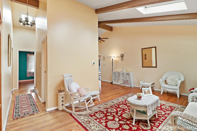 living room featuring beamed ceiling, high vaulted ceiling, wood-type flooring, and ceiling fan with notable chandelier