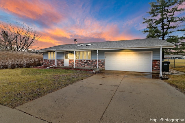 ranch-style home with a garage and a yard