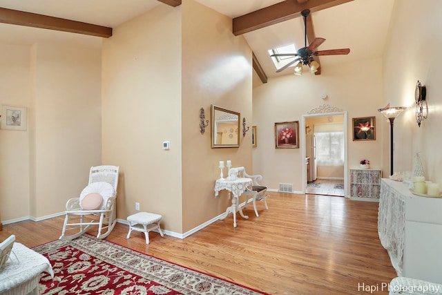 foyer with wood-type flooring, a skylight, beamed ceiling, and ceiling fan