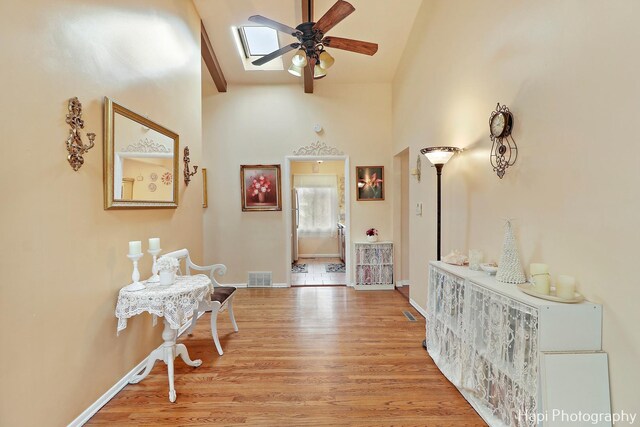 corridor featuring light hardwood / wood-style flooring and high vaulted ceiling