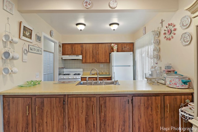 kitchen with sink, white appliances, and decorative backsplash