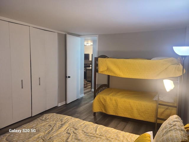 bedroom with dark hardwood / wood-style flooring and a closet