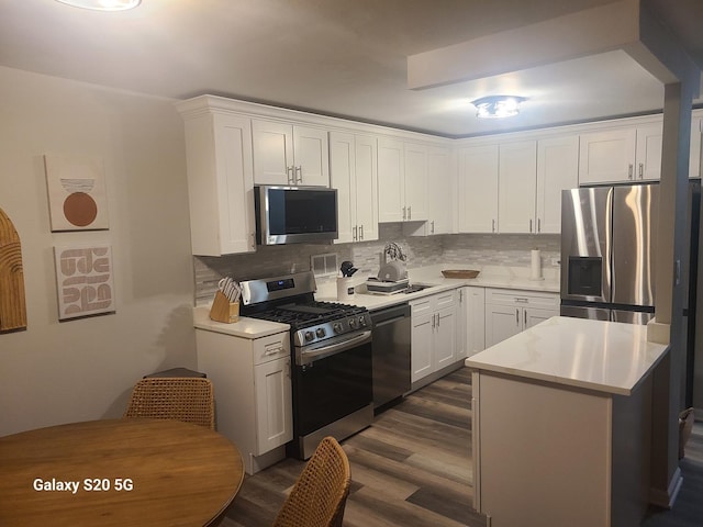 kitchen featuring appliances with stainless steel finishes, tasteful backsplash, sink, white cabinets, and dark hardwood / wood-style flooring