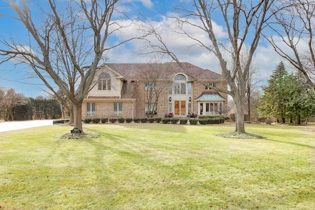 view of front of property with a front lawn and brick siding