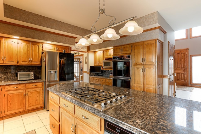 kitchen with a healthy amount of sunlight, appliances with stainless steel finishes, pendant lighting, and backsplash