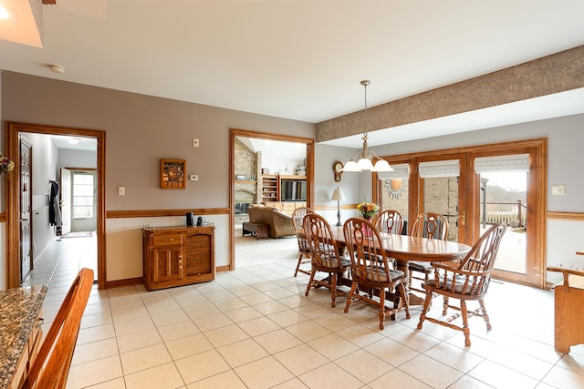 tiled dining room featuring an inviting chandelier