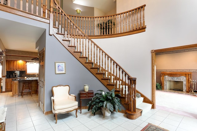 stairs featuring tile patterned flooring and a towering ceiling