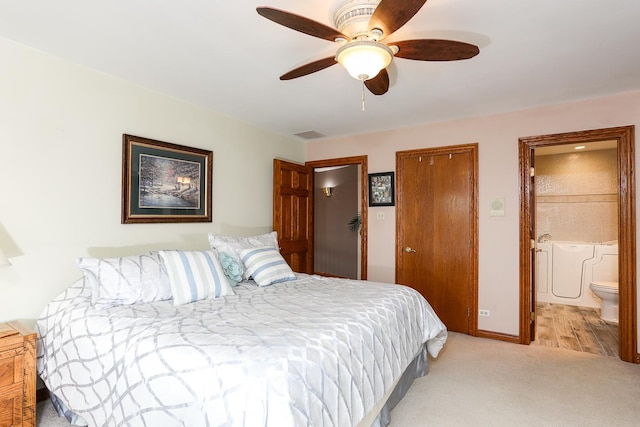 carpeted bedroom featuring ceiling fan, ensuite bath, and a closet