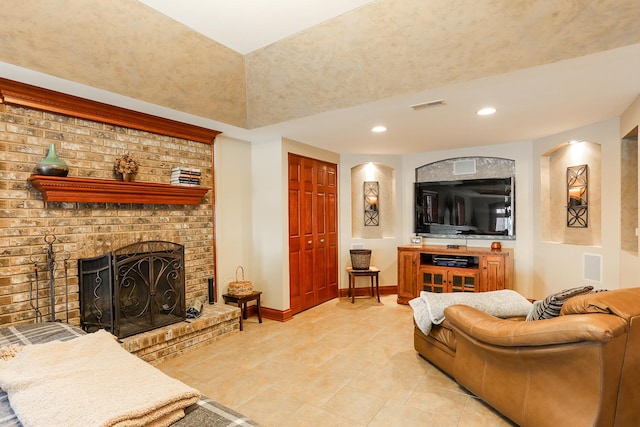 living room with a brick fireplace and light tile patterned floors