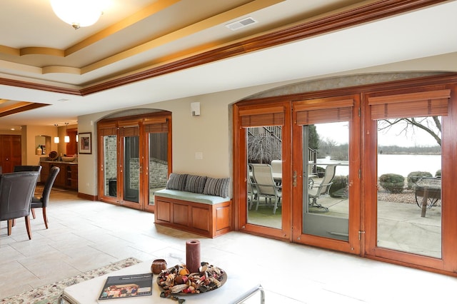 doorway featuring a tray ceiling and a water view