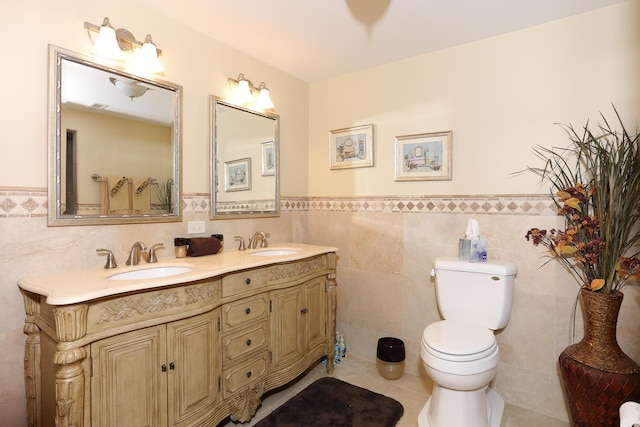 bathroom featuring tile patterned floors, toilet, vanity, and tile walls