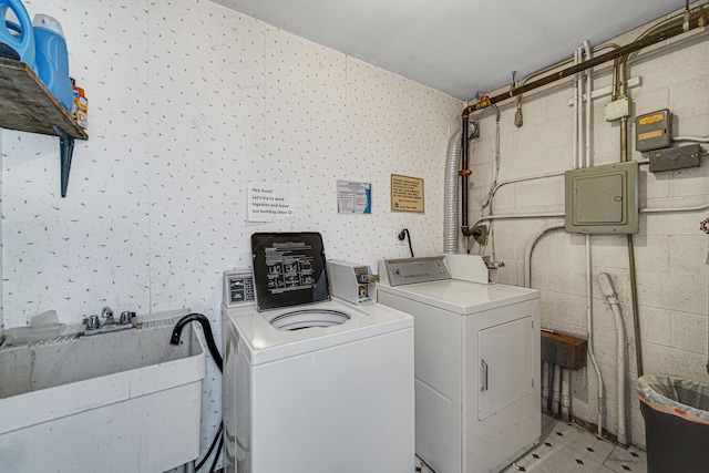 clothes washing area with washing machine and dryer, sink, and electric panel