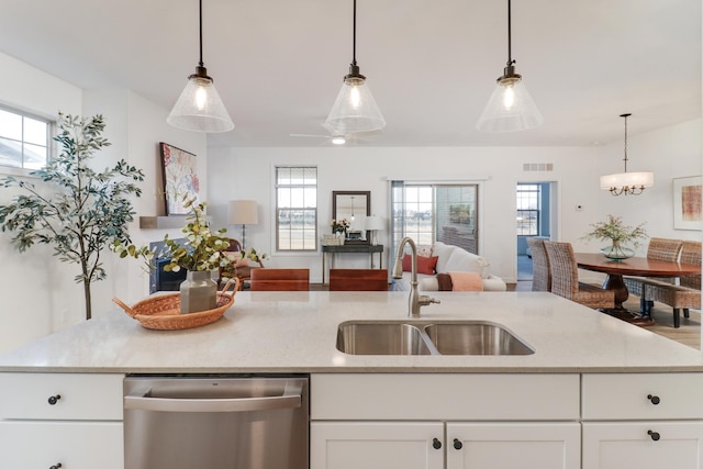 kitchen featuring stainless steel dishwasher, decorative light fixtures, sink, and white cabinets