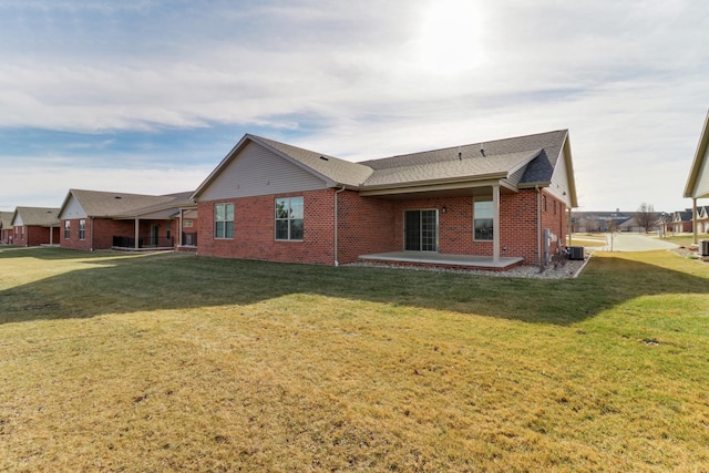 rear view of house with a yard, a patio area, and central air condition unit