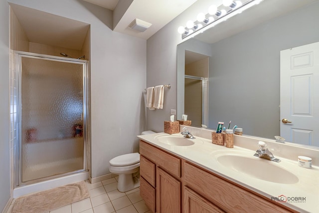 bathroom with tile patterned floors, toilet, a shower with shower door, and vanity