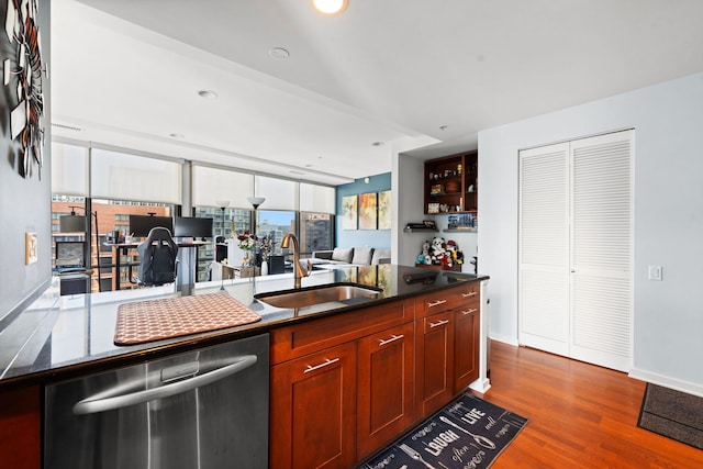 kitchen with stainless steel dishwasher, wood-type flooring, and sink