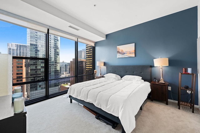 carpeted bedroom featuring a wall of windows