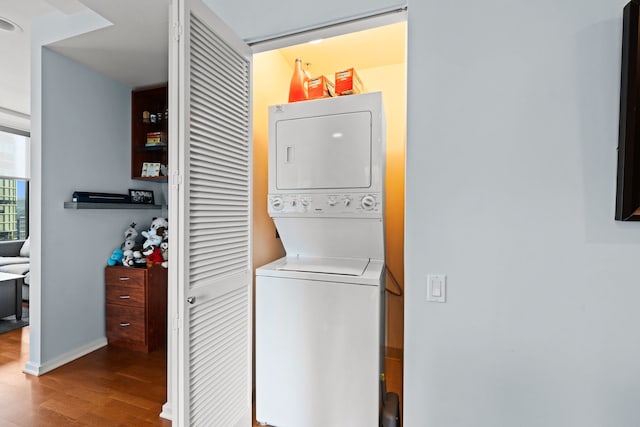 washroom featuring stacked washing maching and dryer and light hardwood / wood-style flooring