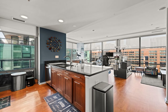 kitchen with sink, dishwasher, floor to ceiling windows, kitchen peninsula, and light wood-type flooring