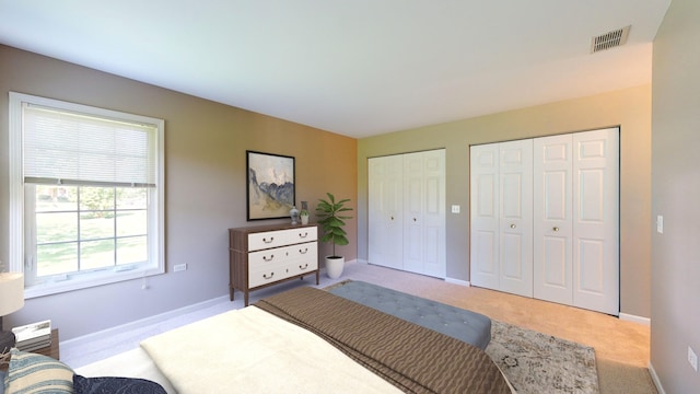 carpeted bedroom featuring two closets