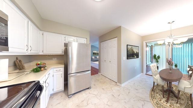 kitchen with white cabinetry, decorative light fixtures, an inviting chandelier, and appliances with stainless steel finishes