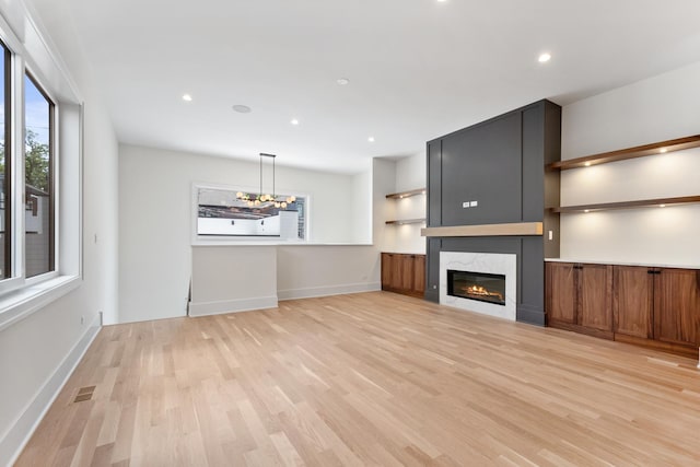 unfurnished living room with light hardwood / wood-style floors and a large fireplace