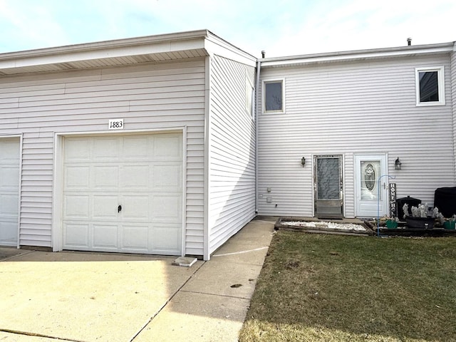 rear view of house featuring a garage and a lawn