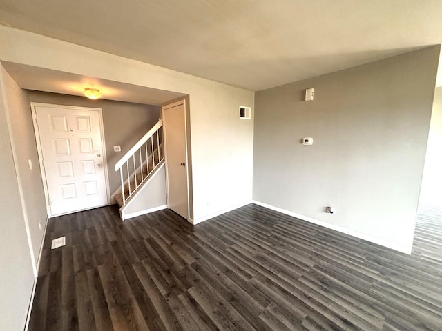 unfurnished room with dark wood-type flooring