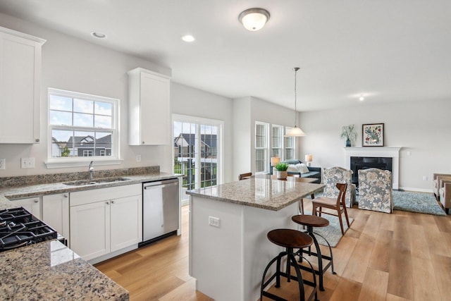 607 Virginia St, Elburn, IL 60119 - kitchen featuring stainless steel dishwasher, open floor plan, light wood finished floors, a kitchen island, and white cabinetry
