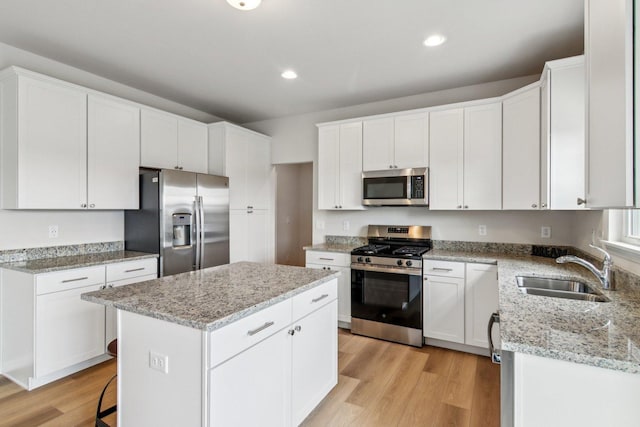 607 Virginia St, Elburn, IL 60119 - kitchen featuring stainless steel appliances, a kitchen island, light wood-style flooring, white cabinets, and light stone counters