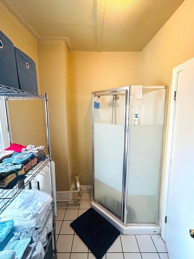 bathroom with an enclosed shower and tile patterned floors