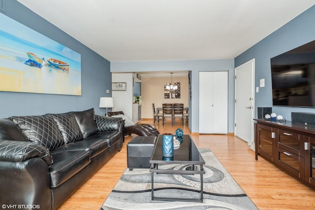 living room featuring a notable chandelier and light hardwood / wood-style flooring